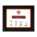 Framed display with trophies and a heart-shaped emblem on a white background
